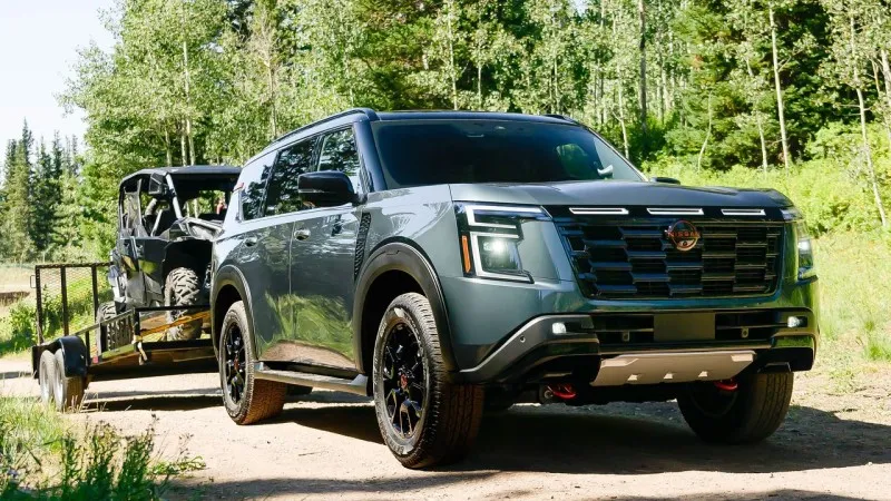 2025 Nissan Armada towing a heavy trailer carrying an ATV.